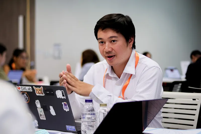 Arnon Tawong discussing ideas with teammates during the hackathon