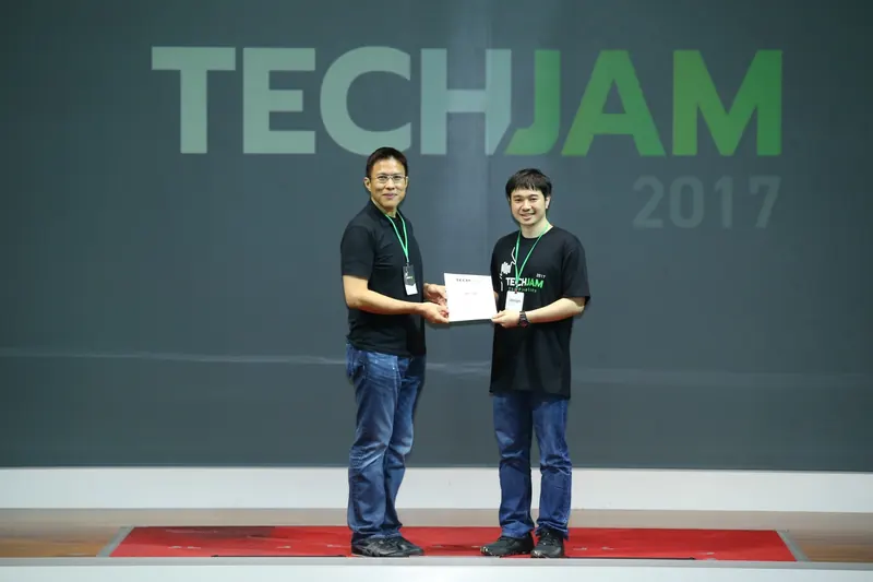 Arnon Tawong receiving a TechJam 2017 finalist certificate on stage